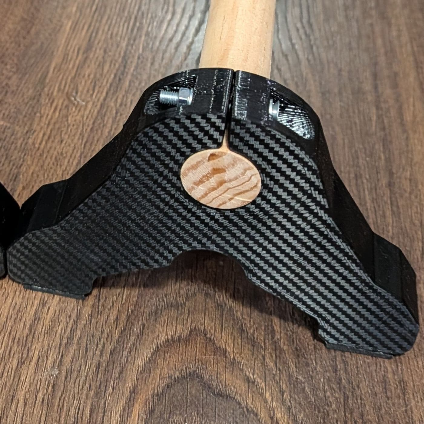 Detalle del soporte: tapa de madera redonda, tornillo de sujeción y barra de madera